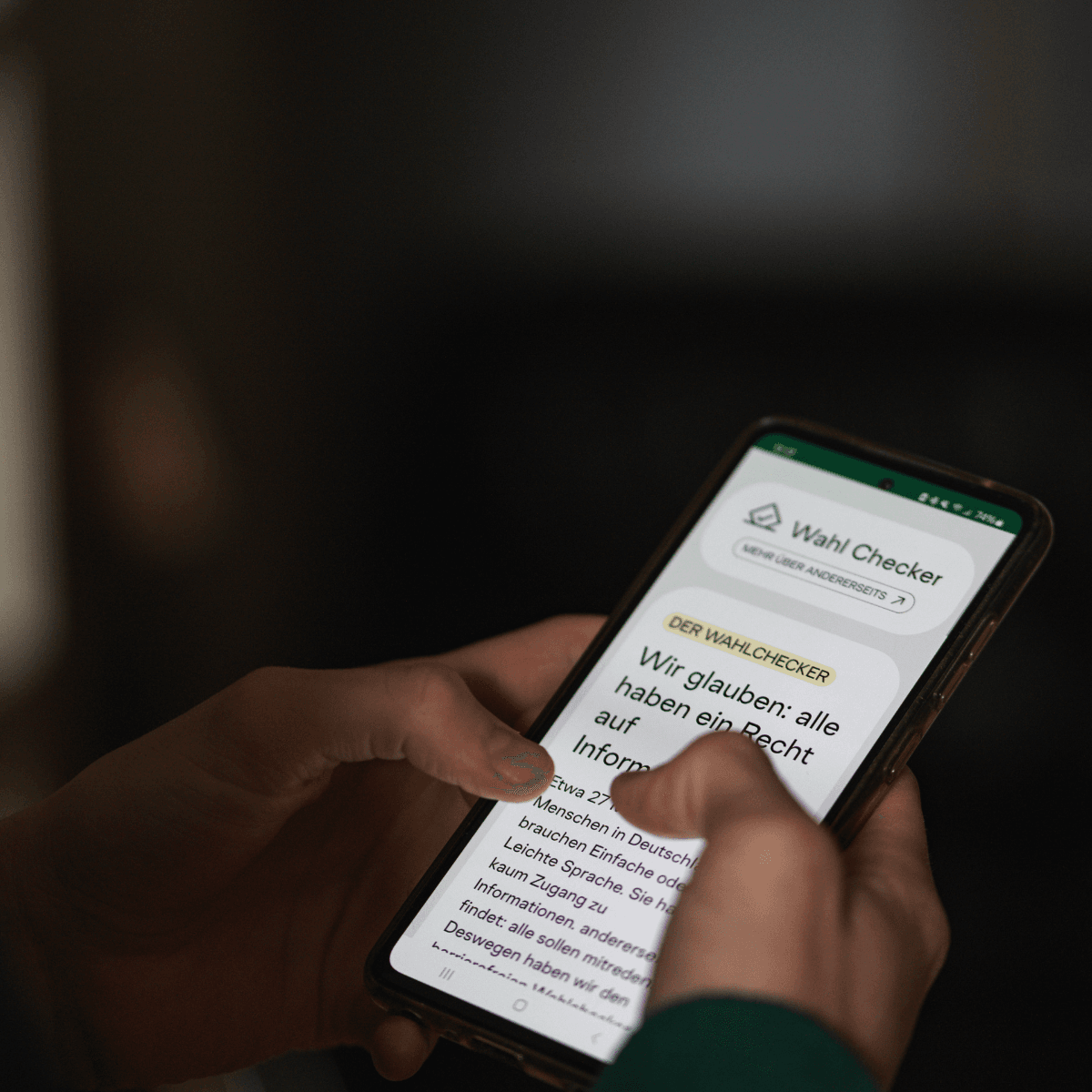Eine Person hält ein Smartphone in der Hand. Das Display zeigt die Startseite vom Wahl-Checker.